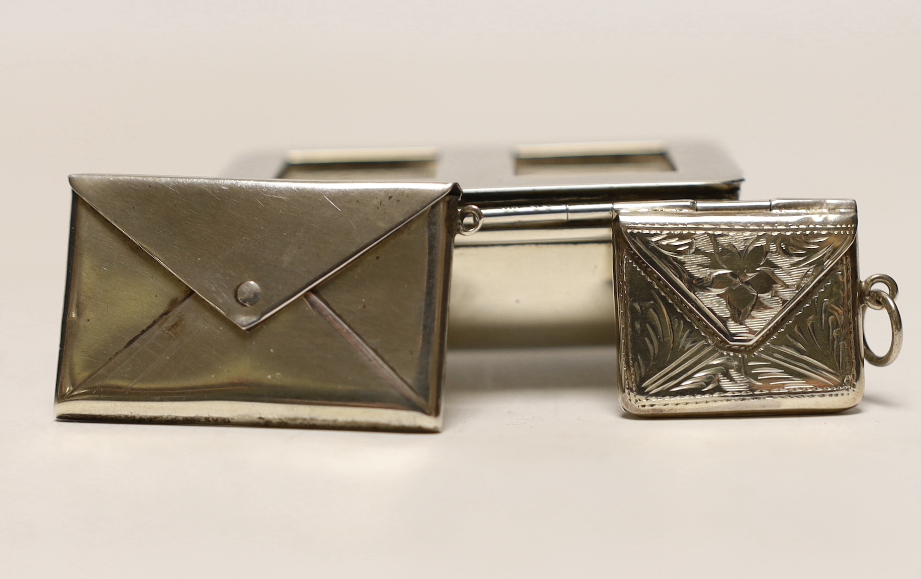 A late Victorian novelty silver double stamp case, modelled as a trough, Levi & Salaman, Birmingham, 1899 and two other silver or 925 'envelope' stamp cases.